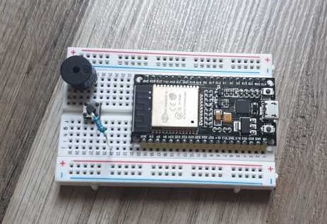 Zu sehen ist das Breadboard mit dem ESP32, dem passiven Buzzer, dem Taster und dem Widerstand
